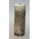 A CHINESE ARCHAIC STYLE CYLINDRICAL JADE BEAD, decorated with a repeated scroll design, 2.25in