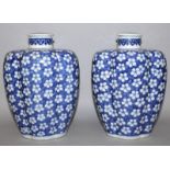 A PAIR OF CHINESE BLUE & WHITE PORCELAIN JARS & COVERS, each high shouldered quatrefoil section body