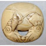 A SMALL JAPANESE MEIJI PERIOD IVORY NETSUKE, rendered as one half of a temple bell, each side carved