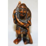 A GOOD JAPANESE EDO/MEIJI PERIOD BOXWOOD NETSUKE OF A STANDING SAGE, leaning on a knarled and