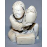 A SIGNED JAPANESE MEIJI PERIOD IVORY NETSUKE OF A SEATED MAN, holding aloft a Daruma doll, the