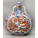 A CHINESE IRON-RED & UNDERGLAZE-BLUE PORCELAIN MOON FLASK, the sides decorated with two panels of