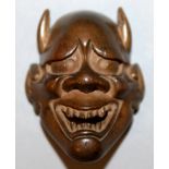 A SIGNED JAPANESE MEIJI PERIOD BOXWOOD MASK NETSUKE OF HANNYA, with horns and with smiling and