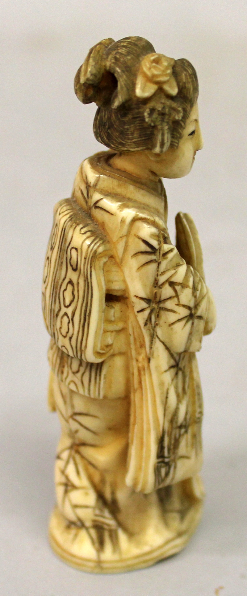 A JAPANESE MEIJI PERIOD IVORY OKIMONO OF A GEISHA, standing in flowing robes and holding a fan, - Image 2 of 5