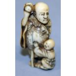 A SIGNED JAPANESE MEIJI PERIOD IVORY NETSUKE, carved in the form of a standing man with bamboo staff