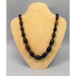 A HORN NECKLACE, composed of graduated oval beads, approx. 25.5in long.