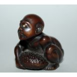 A GOOD JAPANESE MEIJI PERIOD CARVED WOOD NETSUKE OF A BLIND MASSEUR BY GYOKKEI, the man crouching