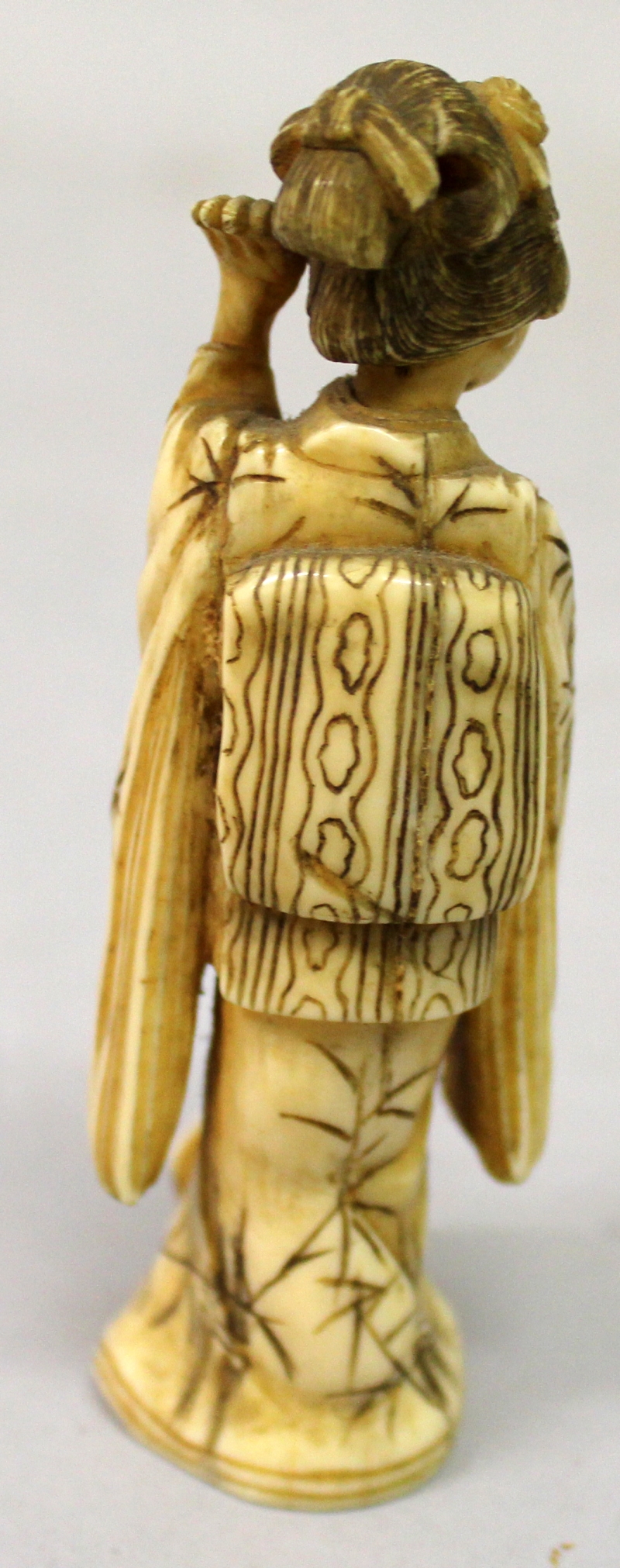 A JAPANESE MEIJI PERIOD IVORY OKIMONO OF A GEISHA, standing in flowing robes and holding a fan, - Image 3 of 5