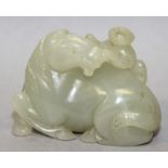 A GOOD QUALITY CHINESE CELADON JADE CARVING OF A HORSE, lying recumbent and with a monkey on its