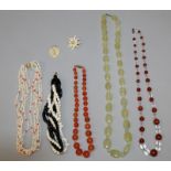 A GROUP OF FIVE BEAD NECKLACES, composed of various materials, and an ivory pendant and a brooch. (