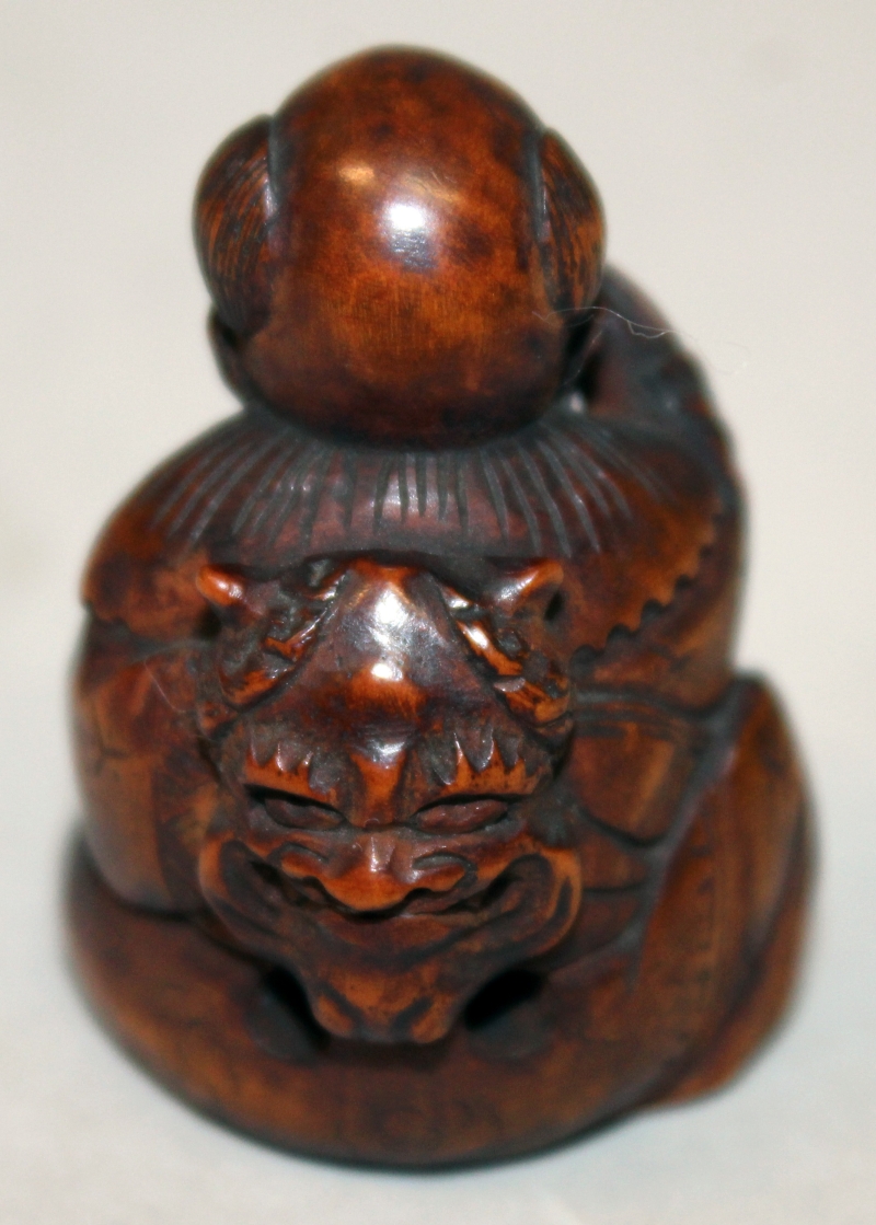 A JAPANESE MEIJI PERIOD WOOD NETSUKE OF A SEATED BOY, with protruding tongue, and holding an oni - Image 3 of 5