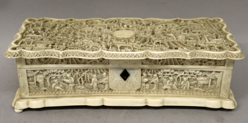 A GOOD 19TH CENTURY CHINESE CANTON IVORY CASKET, the shaped and hinged cover carved in deep relief