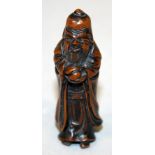 A JAPANESE WOOD SASHI NETSUKE OF FUKUROKUJU, standing in flowing robes and holding a peach, 2.9in