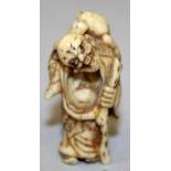 A JAPANESE MEIJI PERIOD BONE IVORY NETSUKE OF GAMMA SENNIN, the standing sage holding a staff and