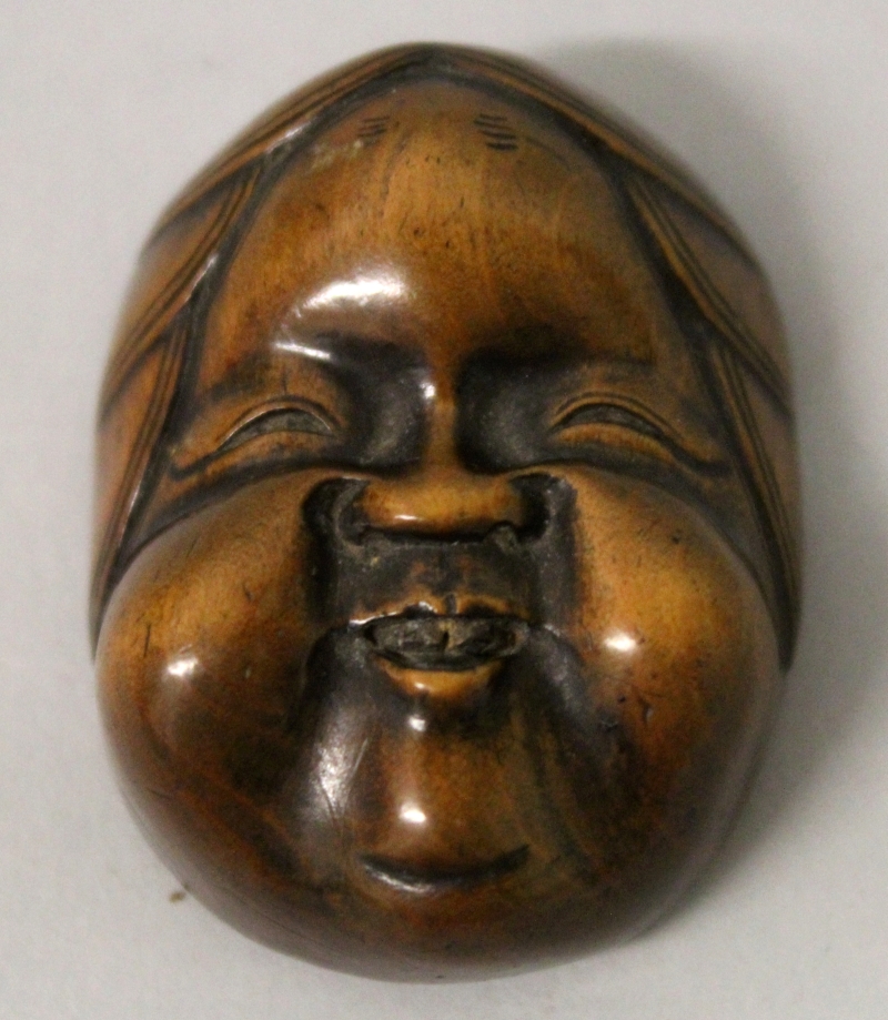 A GOOD QUALITY SIGNED JAPANESE MEIJI PERIOD BOXWOOD MASK NETSUKE OF OKAME, with jovial features, the