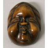 A GOOD QUALITY SIGNED JAPANESE MEIJI PERIOD BOXWOOD MASK NETSUKE OF OKAME, with jovial features, the