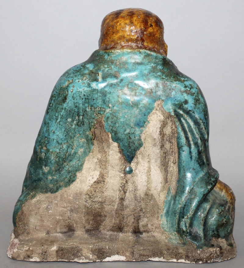 A 16TH CENTURY CHINESE MING DYNASTY FAHUA POTTERY FIGURE OF BUDAI, seated with exposed belly and one - Image 2 of 3