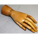 A 1920'S CARVED WOOD ARTICULATED HAND. 8.5ins long.