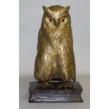 A SUPERB BROWN WISE OWL with glass eyes and lift up head standing on a bronze boot. 11ins high.