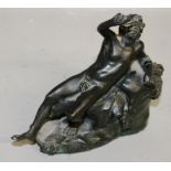 AFTER THE ANTIQUE A reclining bronze figure on a rock.  5ins long.