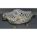 A GOOD LARGE OVAL TWO HANDLED PIERCED BASKET painted and encrusted with flowers, with rustic handles