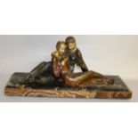 AN ART DECO SPELTER FIGURE GROUP of two reclining young ladies reading, on a rectangular marble