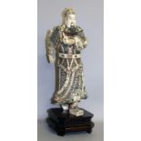 A 20TH CENTURY JAPANESE STAINED BONE FIGURE OF A MAN on a pedestal base. Figure 16ins high.