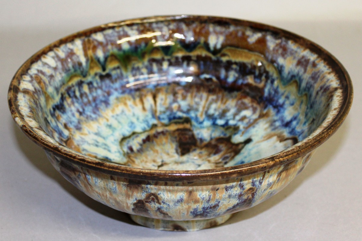 A STONEWARE STUDIO POTTERY BOWL with splash decoration. 9.5ins diameter.