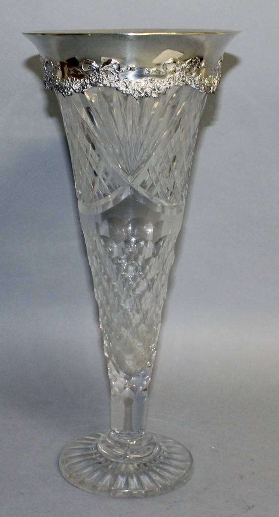 A TIFFANY & CO TALL CUT GLASS TRUMPET SHAPED VASE with silver rim. 14.5ins high.