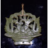 AN EARLY 20TH CENTURY CHINESE DARK CELADON PIERCED JADE PENDANT, supported on a gold-metal