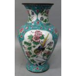 AN EARLY 20TH CENTURY CHINESE CANTON ENAMEL VASE, the sides decorated with shaped panels of birds