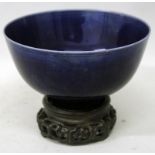 A CHINESE BLUE GLAZED PORCELAIN BOWL, together with a wood stand, the sides with underglaze