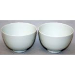 A PAIR OF CHINESE WHITE GLAZED PORCELAIN CUPS, the glaze with a bluish tinge, each base with a