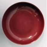 A CHINESE SANG-DE-BOEUF PORCELAIN SAUCER DISH, applied with an even glaze pooling slightly at the
