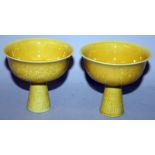 A PAIR OF CHINESE YELLOW ENAMELLED PORCELAIN STEM BOWLS, each incised underneath the glaze with