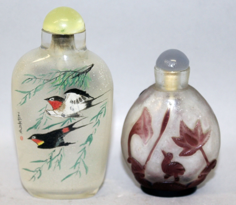 TWO 20TH CENTURY CHINESE GLASS SNUFF BOTTLES & STOPPERS, one interior painted, the second of red