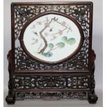 A GOOD 19TH CENTURY CHINESE FAMILLE ROSE PORCELAIN AND PIERCED HARDWOOD TWO SECTION SCREEN, the