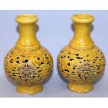 A PAIR OF CHINESE PIERCED YELLOW GLAZED VASES, each decorated with repeated Shou medallions reserved