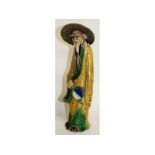 A large Chinese figure of a man carrying a fan. 17ins high.