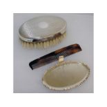 A travelling set with silver back brush, a mirror and a comb.