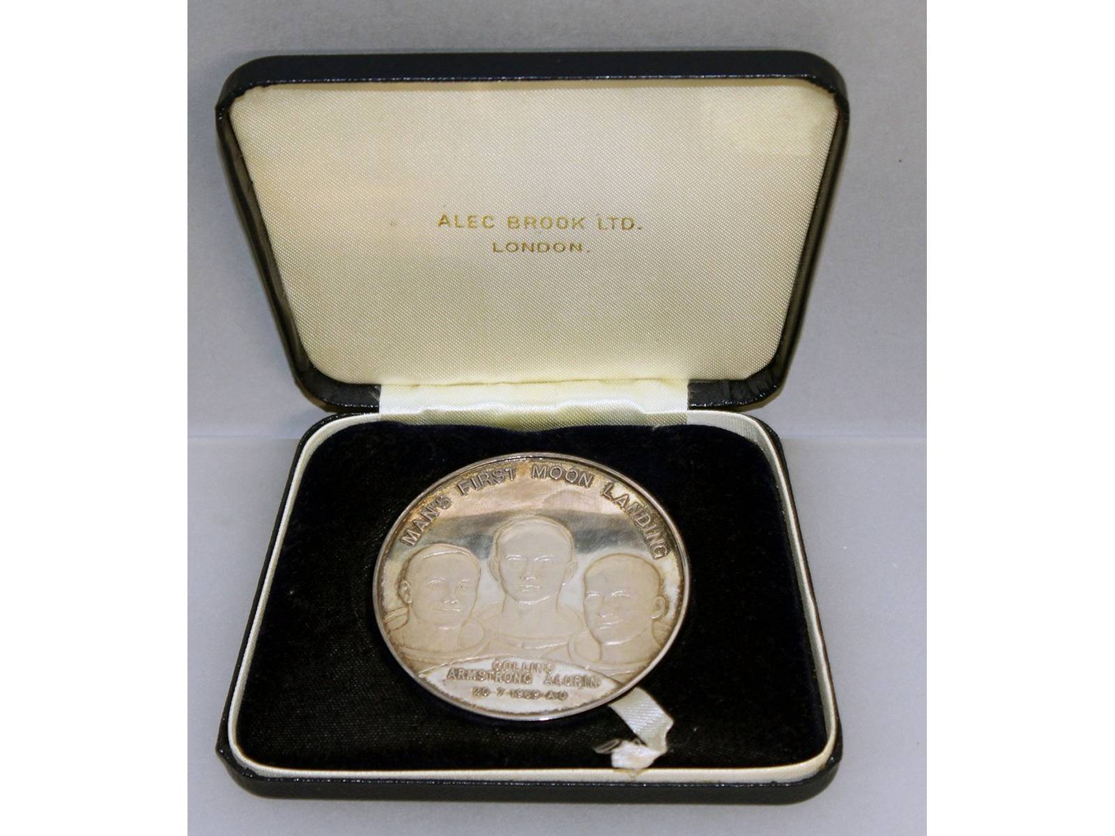 A silver medallion "Mans First Landing on the Moon", No. 2363, in a case.