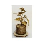 A silver gilt flower arrangement, on a rustic ivory base. 8cms high.