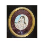 An Indian oval miniature of a young girl, 3.5cms x 3cms, in an ebony frame.