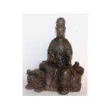 An early cast iron Chinese Guanyin riding a Dog of Foe. Signed. 12ins high.