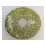 A Chinese carved jade circular disc. 13cms diameter.