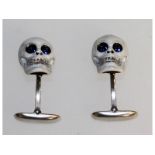 A pair of sterling silver and enamel cufflinks in the form of skulls.