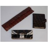 A silver mounted crocodile purse, a silver mounted comb in a leather case and a crocodile