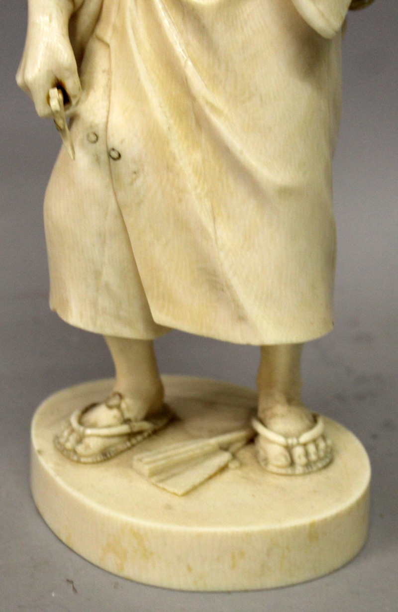 A LARGE GOOD QUALITY JAPANESE MEIJI PERIOD TOKYO SCHOOL IVORY OKIMONO OF A STANDING MAN, holding - Image 7 of 8