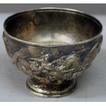 A 20TH CENTURY JAPANESE WHITE METAL EMBOSSED DRAGON BOWL, weighted, the sides decorated with two