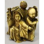 A JAPANESE MEIJI PERIOD STAINED IVORY OKIMONO OF A GROUP OF DANCERS, each with animated posture